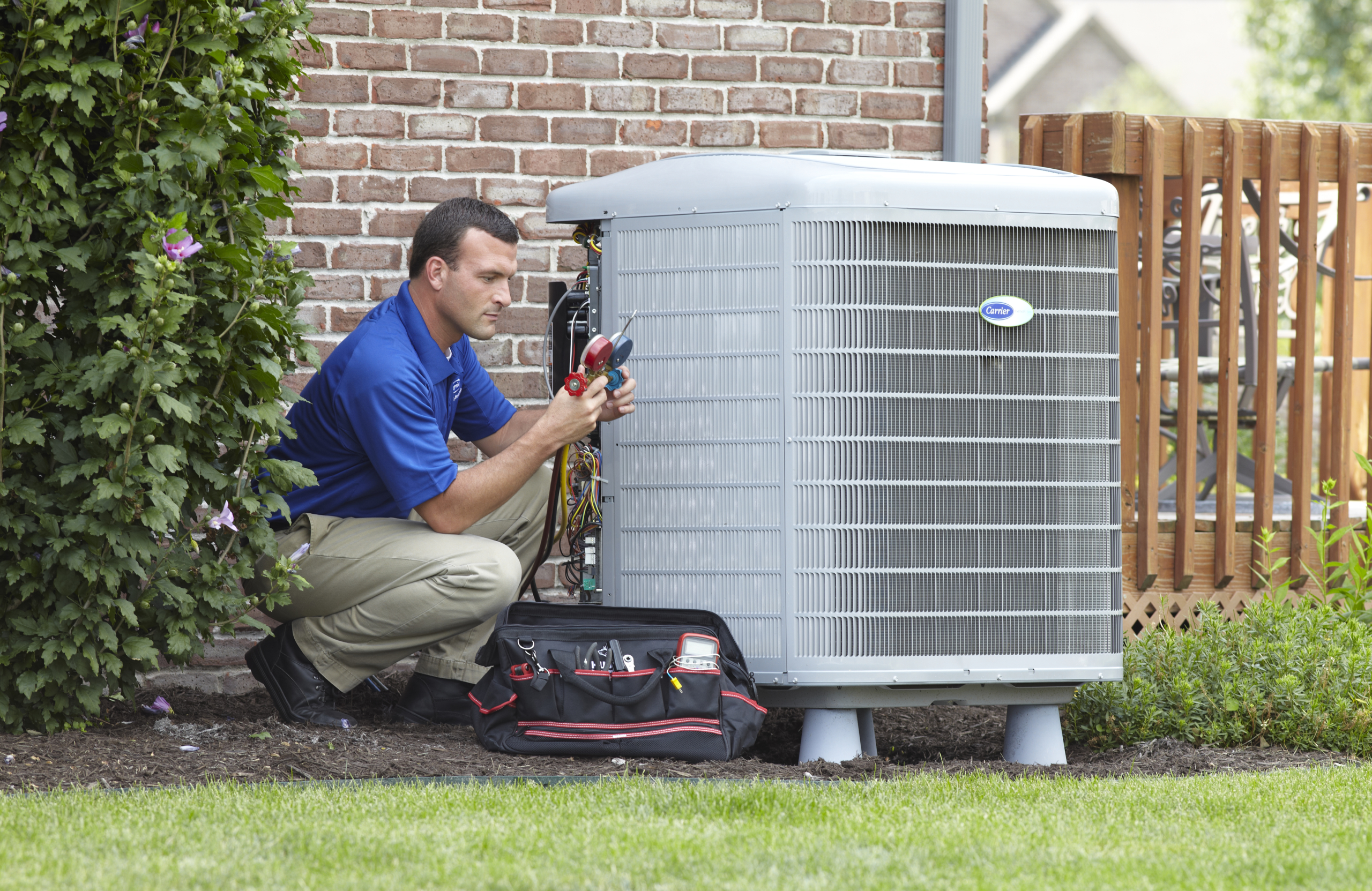 Heating and Cooling-HVAC service tech repairing an air conditioner